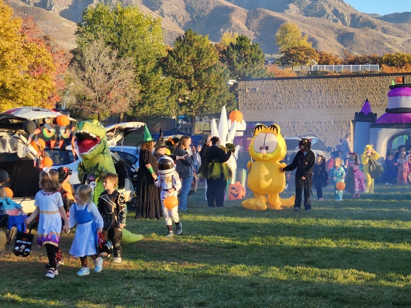 Students doing a costume parade past trunks on the playground field
