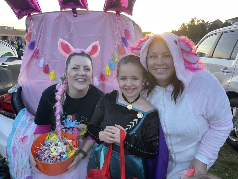 Office staff with a student in front of decorated trunk