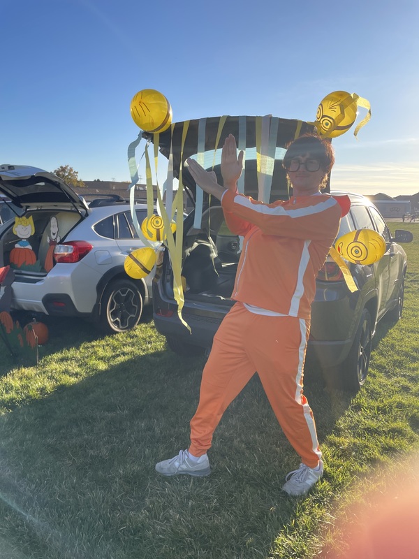 Pe teacher dressed as Vector in front of Minion trunk