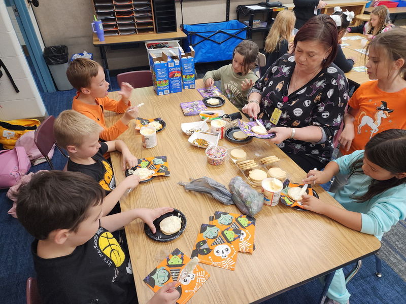 Students decorating cookies at a Halloween party.