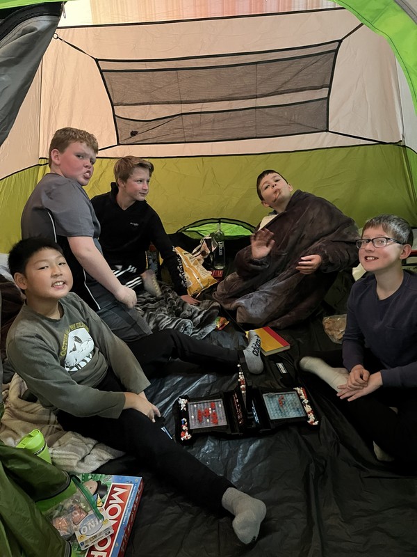 6th graders playing games in a tent