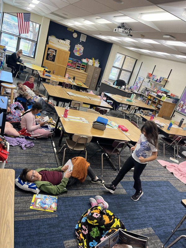 2nd graders laying on blankets reading