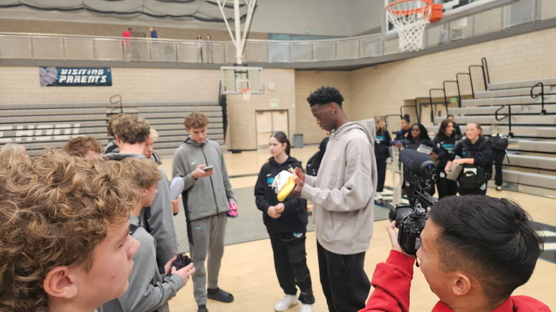 AJ autographing a pair of basketball shoes