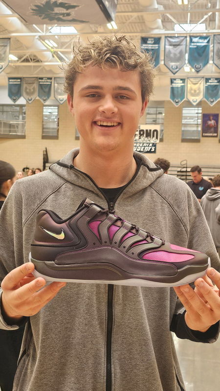 Student holding his new pair of shoes from AJ