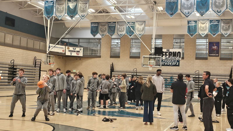 AJ chatting with the students while they shoot the basketball
