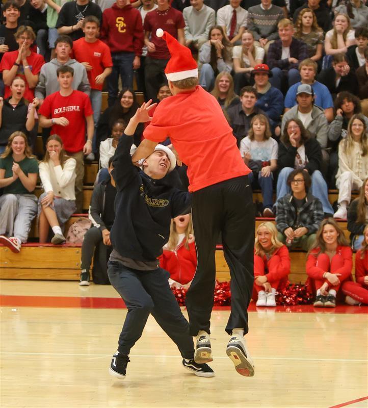 one student taking the santa hat off another student