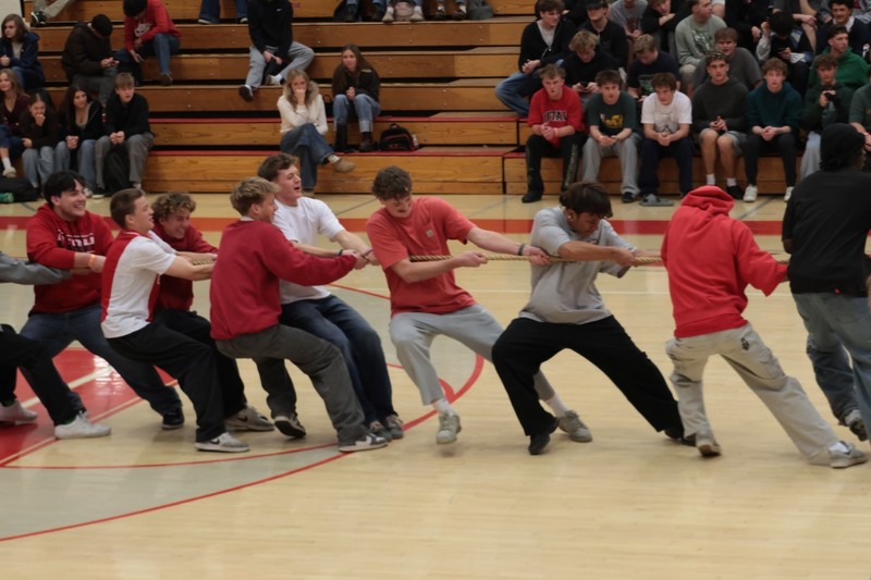 students in red pulling on a rope for tug of war