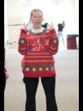 female smiling with her tongue out and putting up two fingers in a holiday sweater