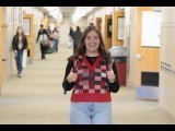 female student giving the thumbs up while wearing a holiday vest