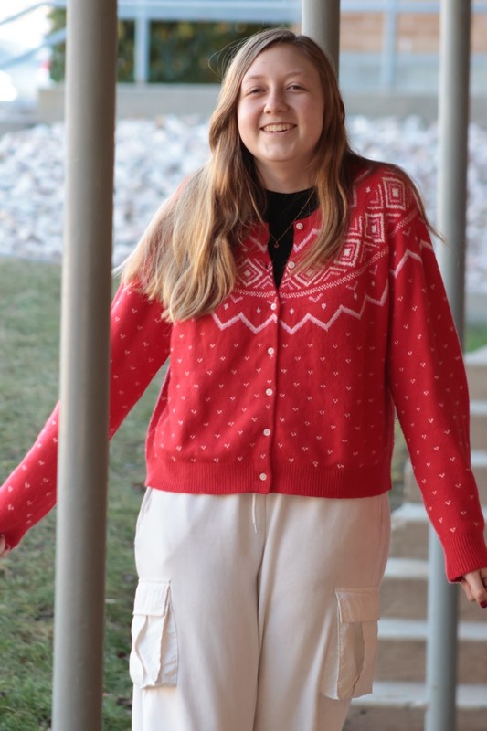 female student smiling at the camera in her holiday sweater