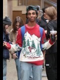 student in a holiday sweater and holding a soda