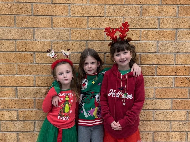 Students in holiday sweaters and headwear
