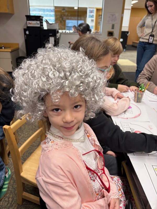 Student dressed as a 100 year old at a desk in a classroom