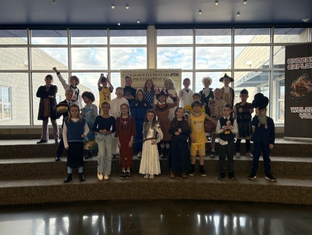 Students dressedin costume as historical figures standing on stairs