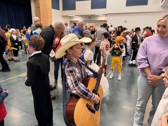 Student dressed as a cowboy with hat and guitar