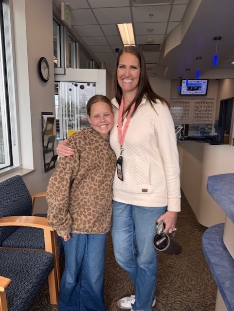 Student standing with her parent in the office.