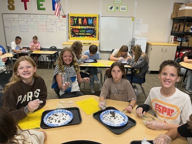 Students in a classroom at a desk dissecting owl pellets