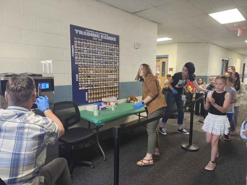 Nr. Nash and others dishing up ice cream cones for students