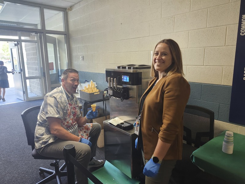 Mr. Nash and Mrs. Neid-Campos by the ice cream machine in the school
