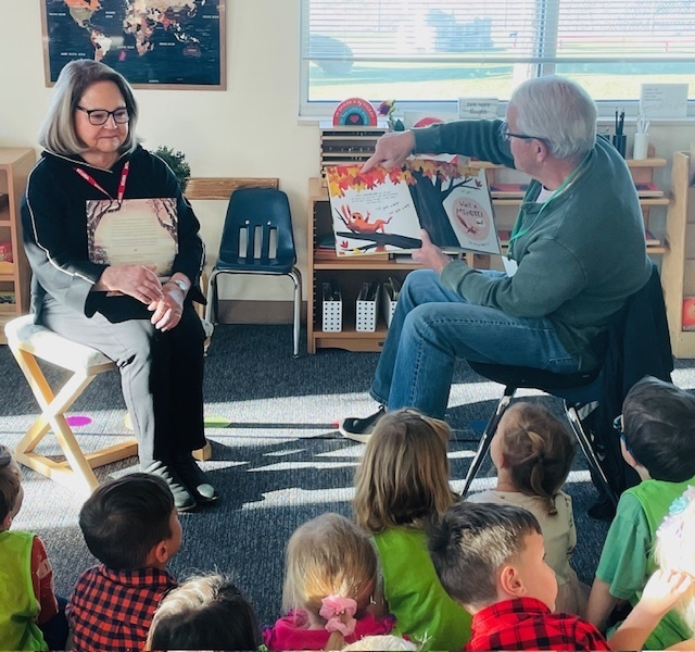 Grandparents reading a story to children