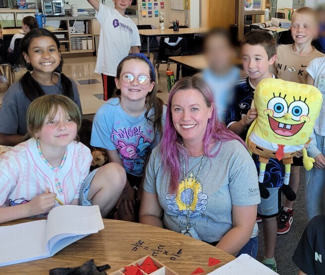 Students surrounding Ms. Rebecca M.