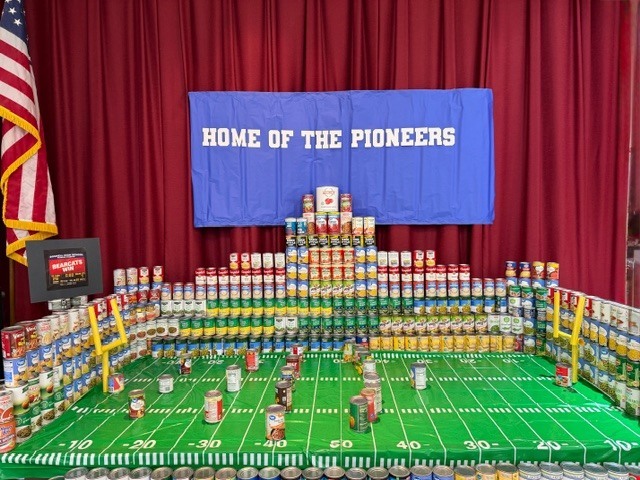 football field made of canned foods on the elementary auditorium stage
