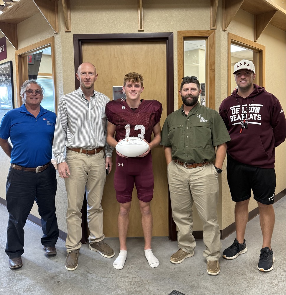 four insurance reps, hs football player and coach in front of coach's office