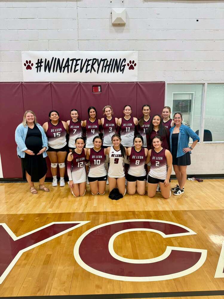 group picture of high school volleyball players and two coaches