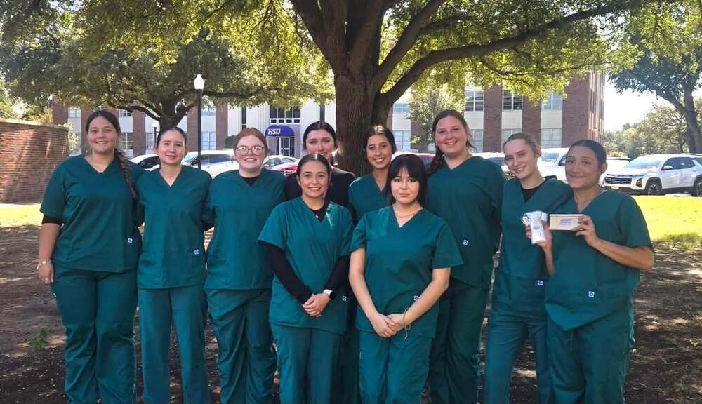 health science students grouped together in front of tree