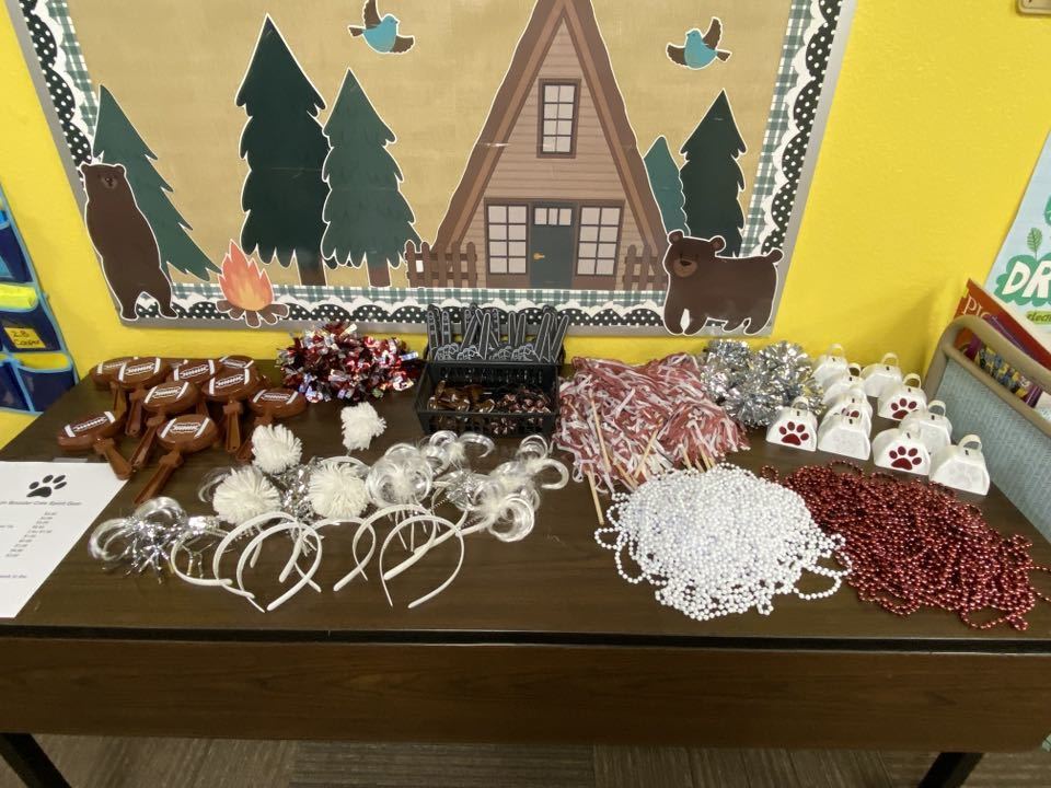 spirit items laid out on table in front of camp theme bulletin board 