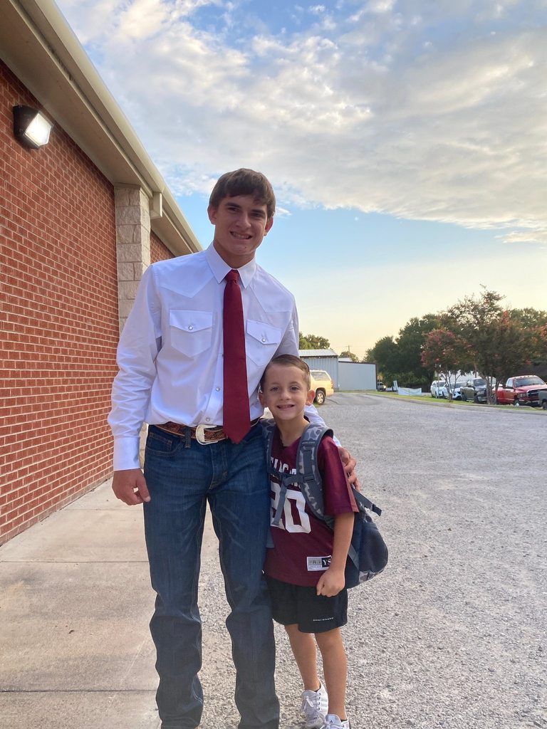 football player posing with boy in football jersey