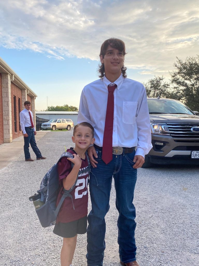 football player posing next to boy in bearcats jersey