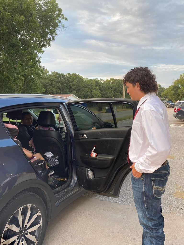 football player opening car door for elementary student
