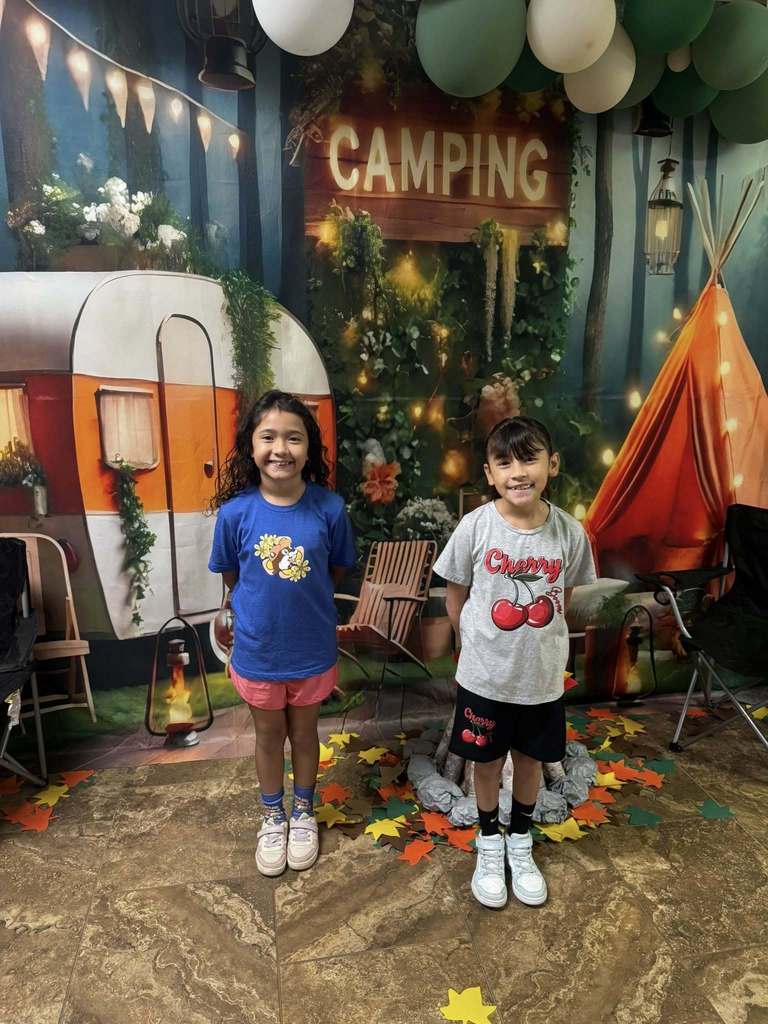 two students standing in front of campfire backdrop