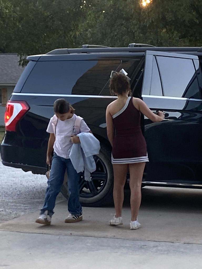cheerleader opening car door for student