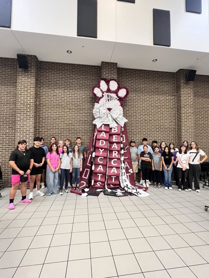floral design classes standing next to giant mum they made for homecoming