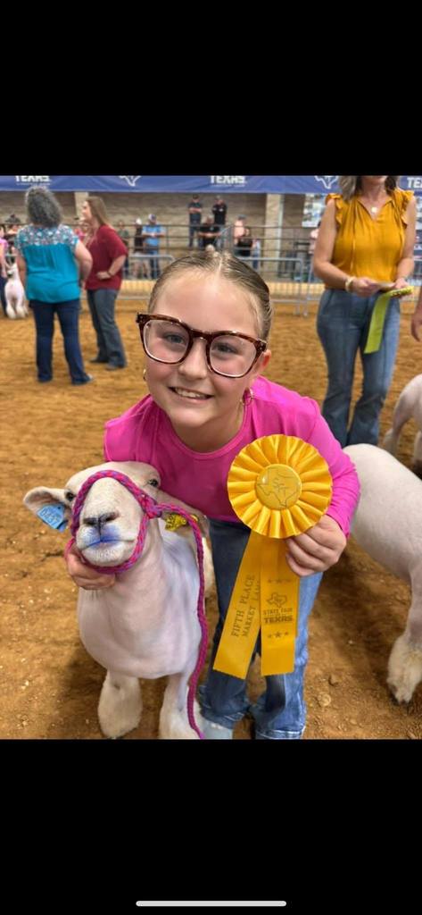ffa member with show lamb and winning ribbon at stock show