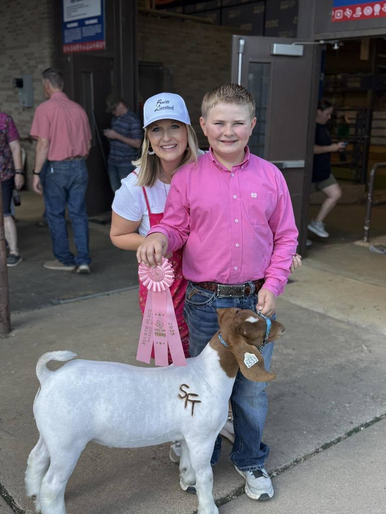 ffa student and parent holding winning ribbon and show animal