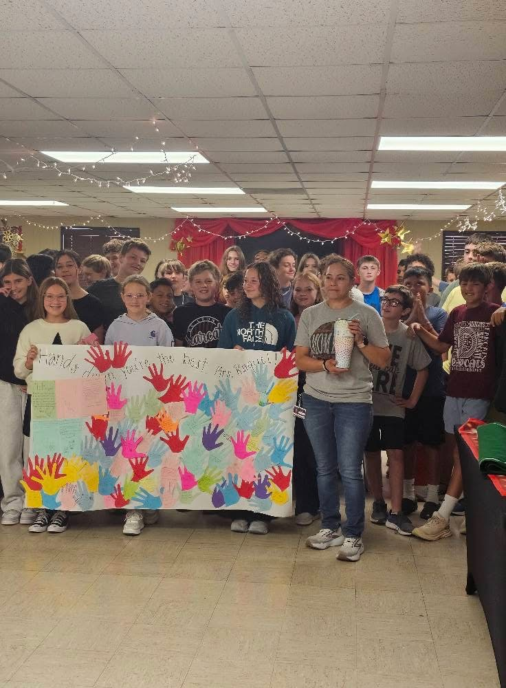 custodian with students holding big sign