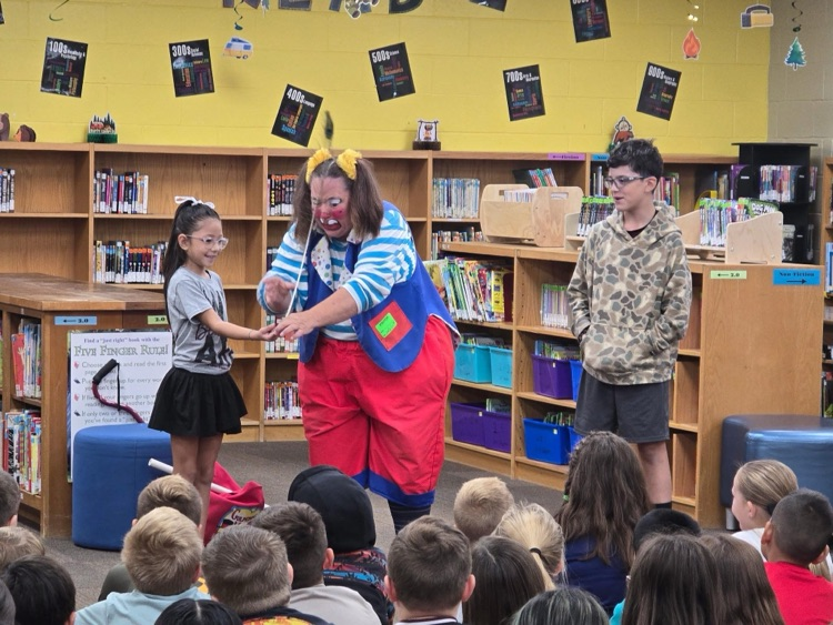 clown doing a demonstration for students in library