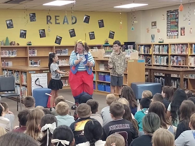 clown doing a demonstration for students in library