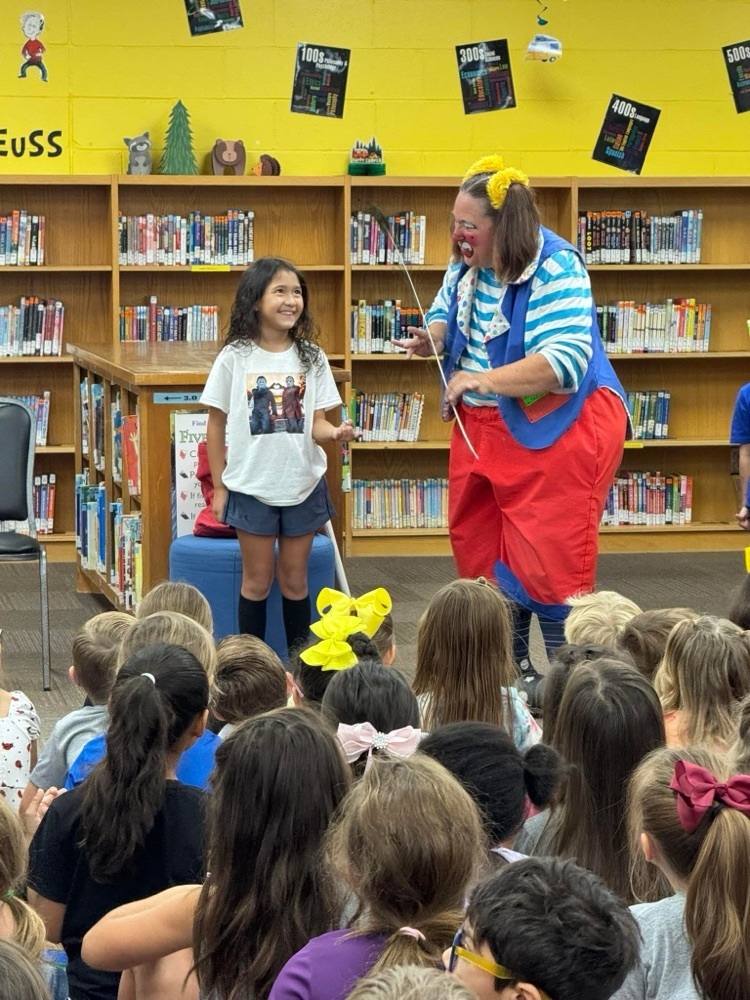 clown doing a demonstration for students in library