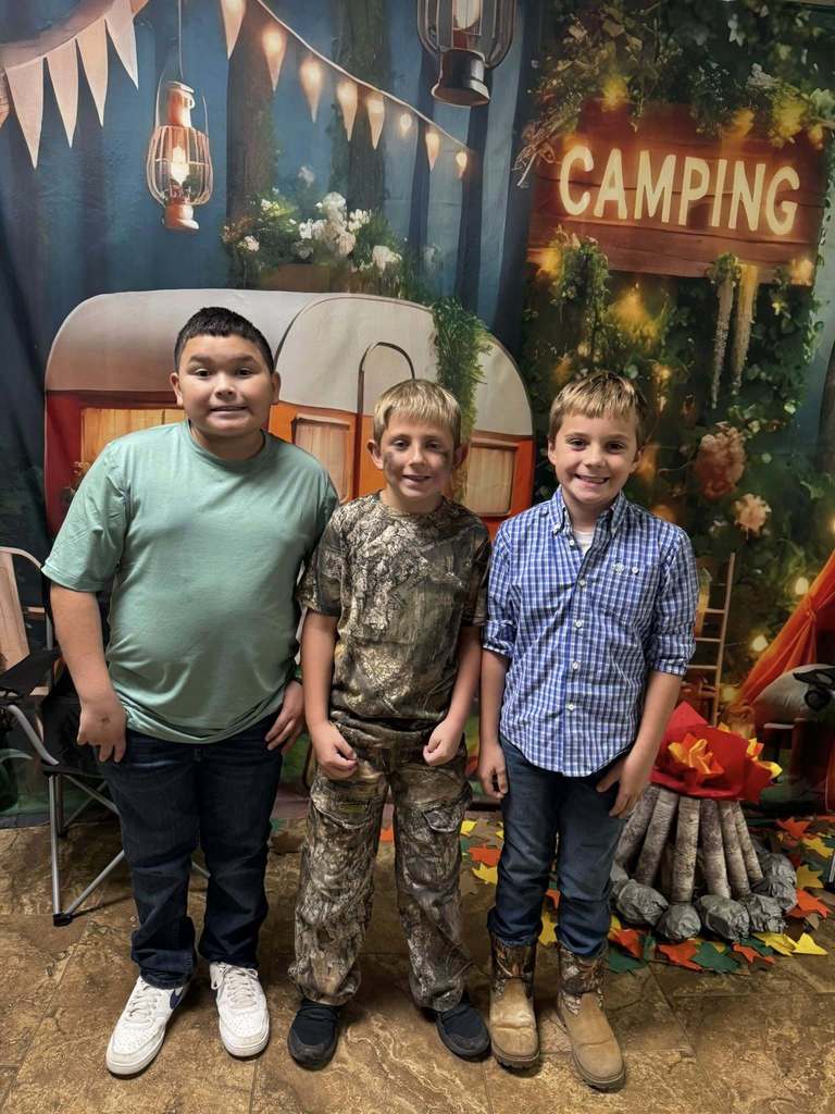 three student campers of the week in front of campsite backdrop