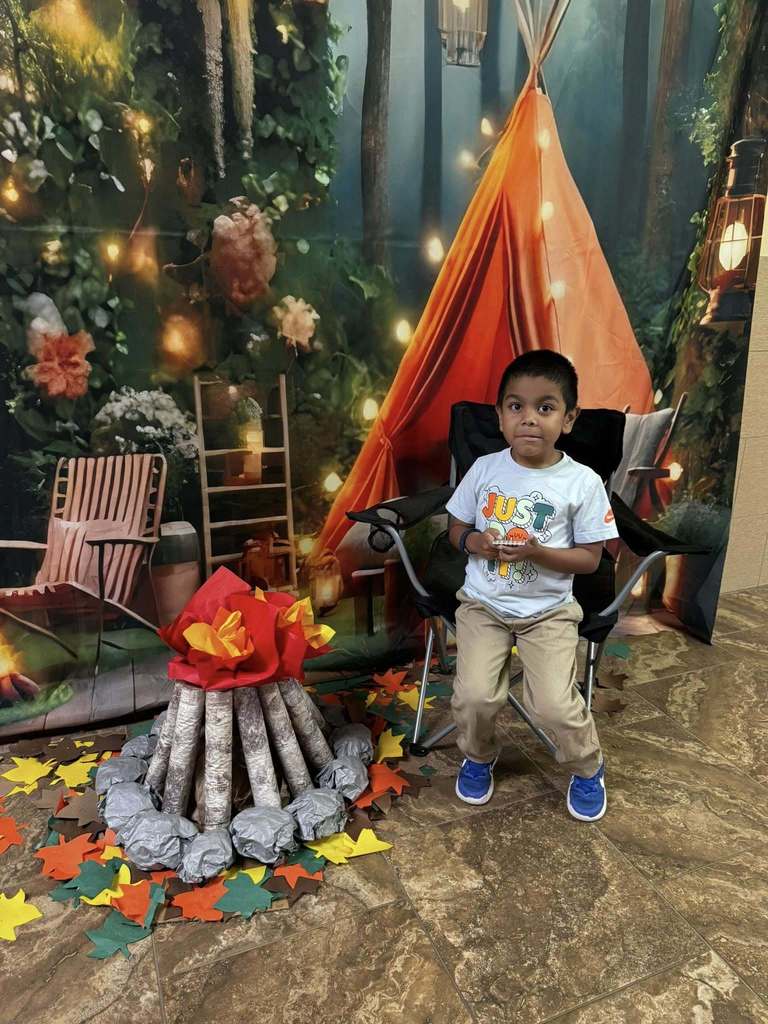 student camper of the week in front of campsite backdrop