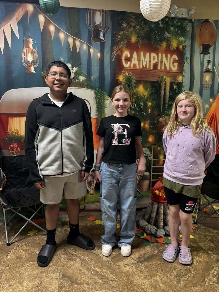 three student campers of the week in front of campsite backdrop
