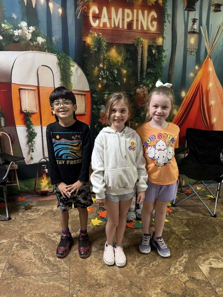 three student campers of the week in front of campsite backdrop