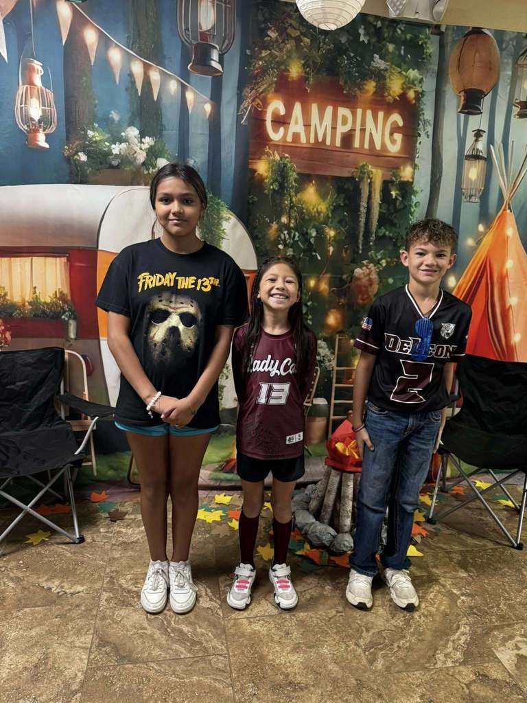 three student campers of the week in front of campsite backdrop