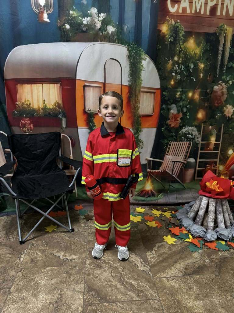 student camper of the week in front of campsite backdrop