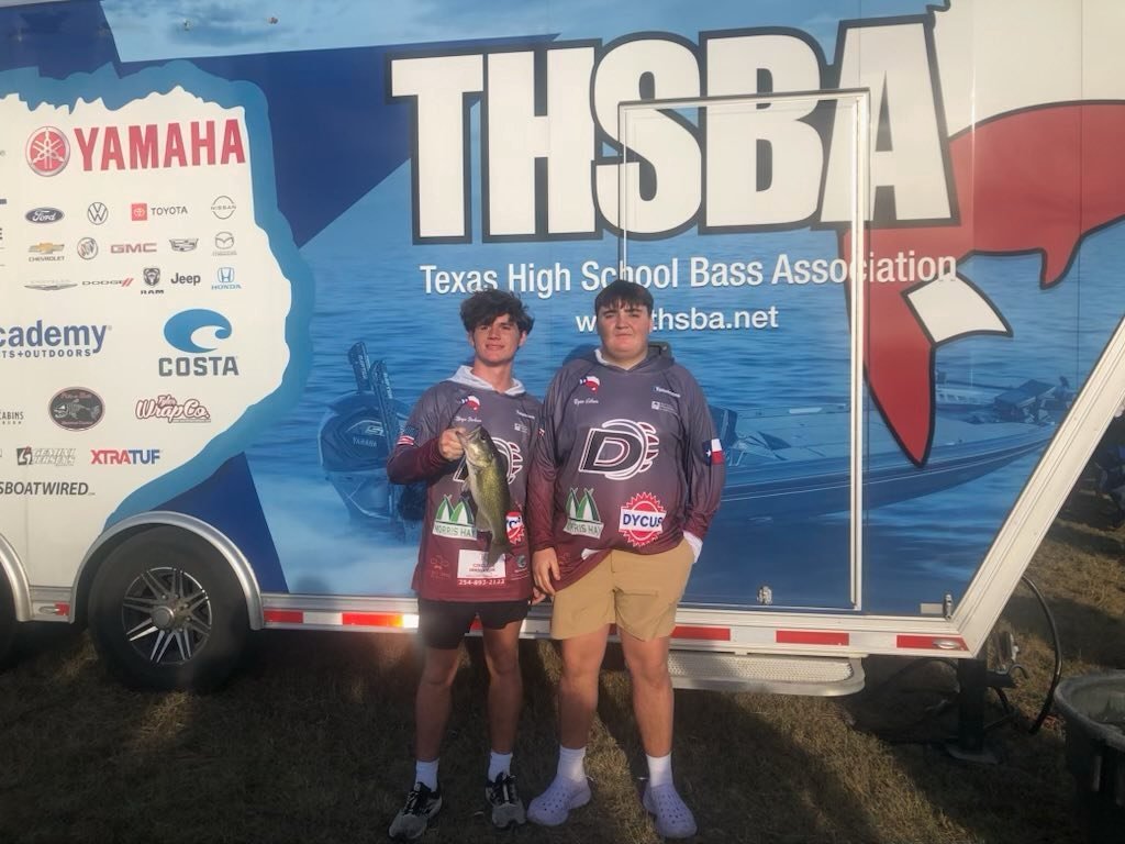 two bass club members holding fish in front of thsba trailer