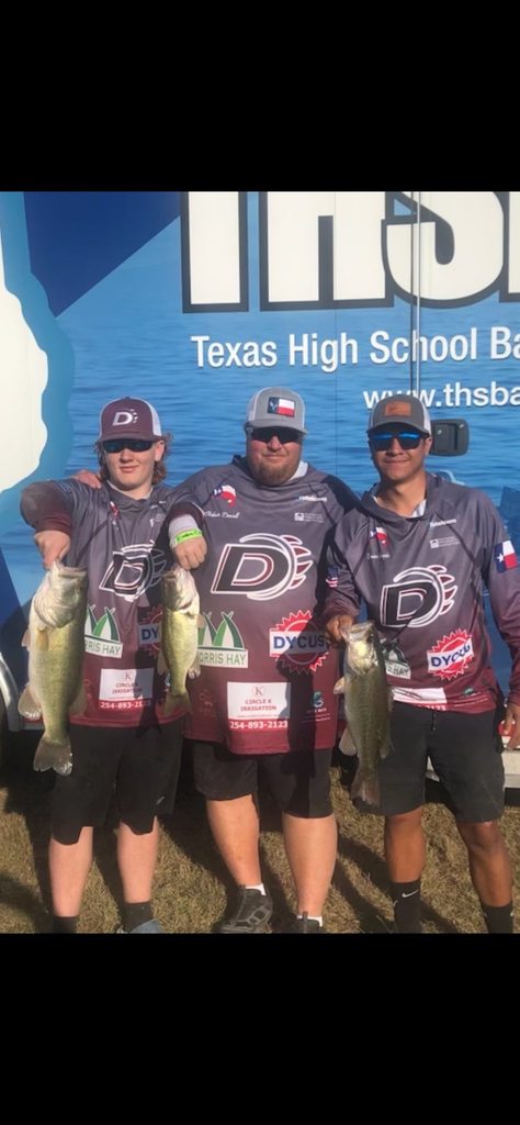 three bass club members holding fish in front of thsba trailer